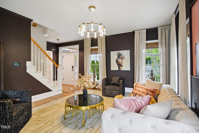 3332 Cheswick Dr, Raleigh, NC 27609 - living area with a chandelier, wood finished floors, baseboards, and stairway