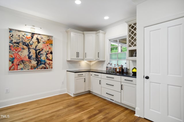 3332 Cheswick Dr, Raleigh, NC 27609 - kitchen featuring white cabinetry, light wood-style flooring, dark countertops, and recessed lighting