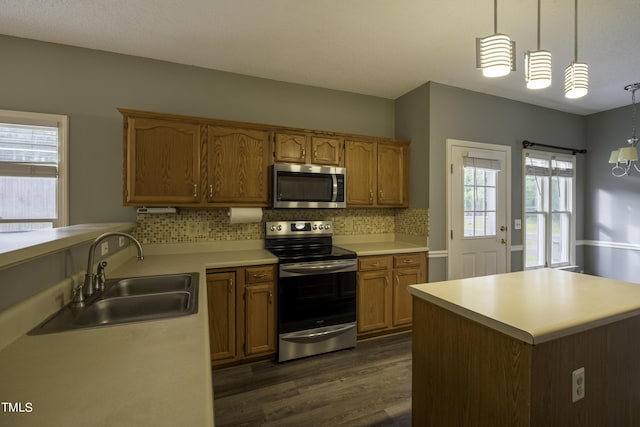 kitchen with a sink, light countertops, dark wood-type flooring, and stainless steel appliances