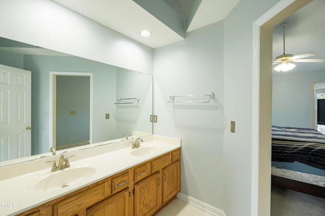 bathroom with double vanity, a ceiling fan, a sink, and connected bathroom