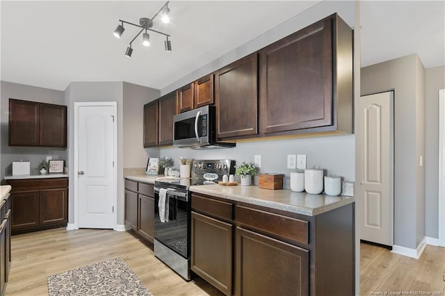 kitchen featuring light wood-style flooring, dark brown cabinets, and stainless steel appliances