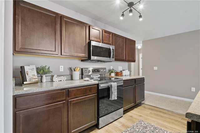 kitchen with dark brown cabinetry, light wood-style flooring, baseboards, and appliances with stainless steel finishes