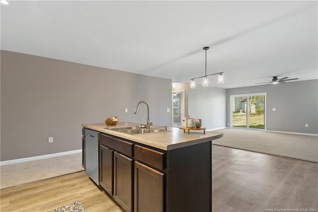 kitchen with stainless steel dishwasher, dark brown cabinetry, light wood-style flooring, a sink, and a center island with sink