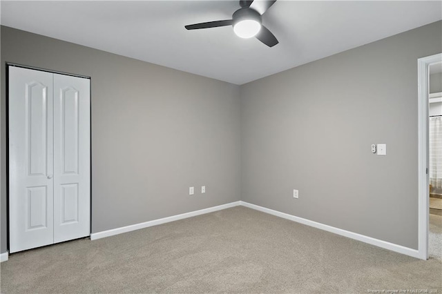 unfurnished bedroom with a closet, carpet flooring, and baseboards