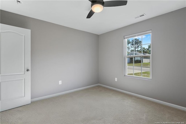 empty room featuring ceiling fan, baseboards, visible vents, and carpet floors