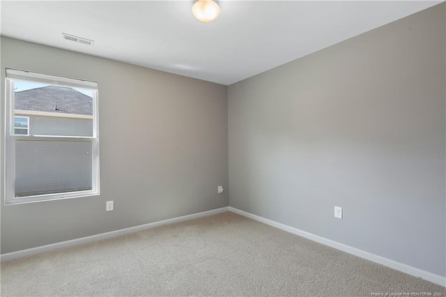 empty room featuring carpet, visible vents, and baseboards