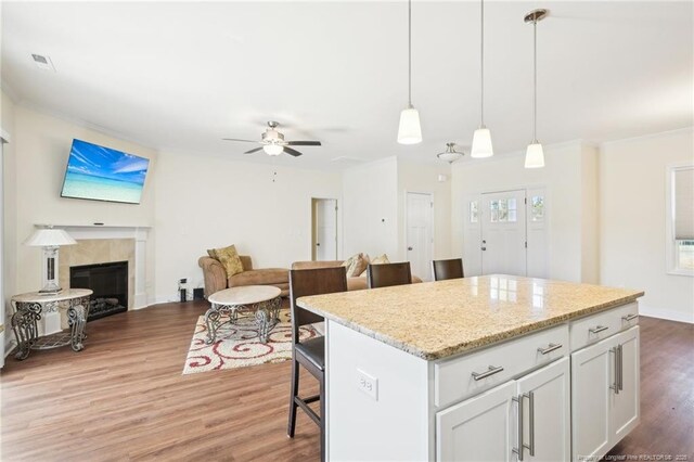 2140 Smith Rd, Hope Mills, NC 28348 - kitchen featuring open floor plan, ceiling fan, a kitchen bar, wood finished floors, and a kitchen island