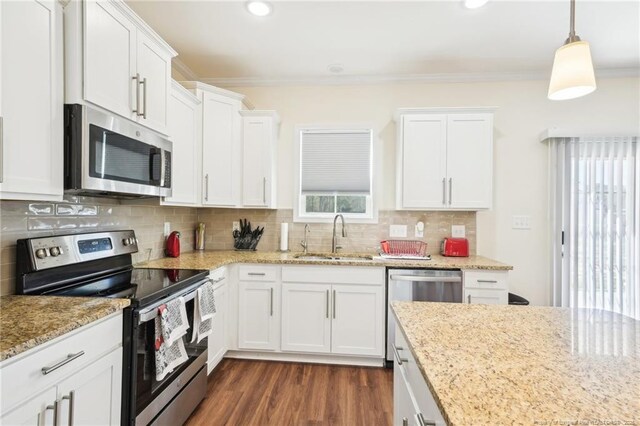 2140 Smith Rd, Hope Mills, NC 28348 - kitchen with white cabinets, a sink, ornamental molding, and appliances with stainless steel finishes