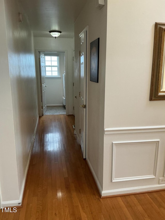 hall with baseboards and hardwood / wood-style flooring
