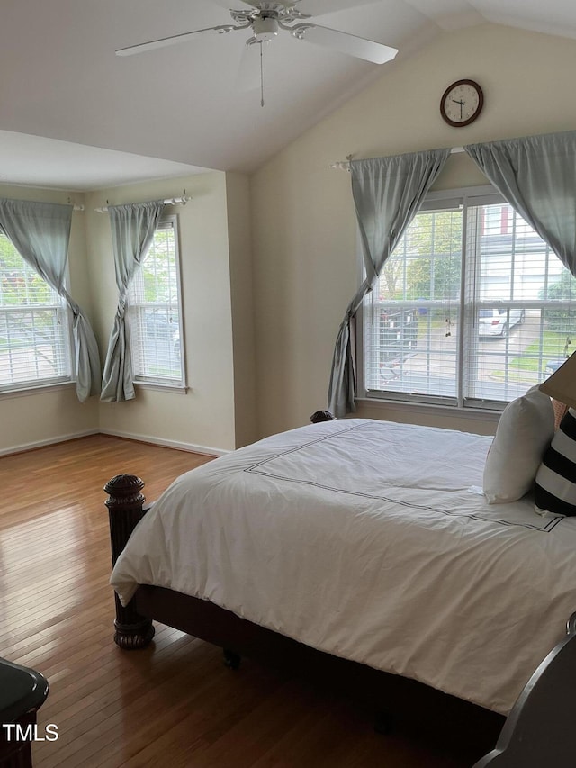 bedroom featuring baseboards, wood finished floors, a ceiling fan, and lofted ceiling