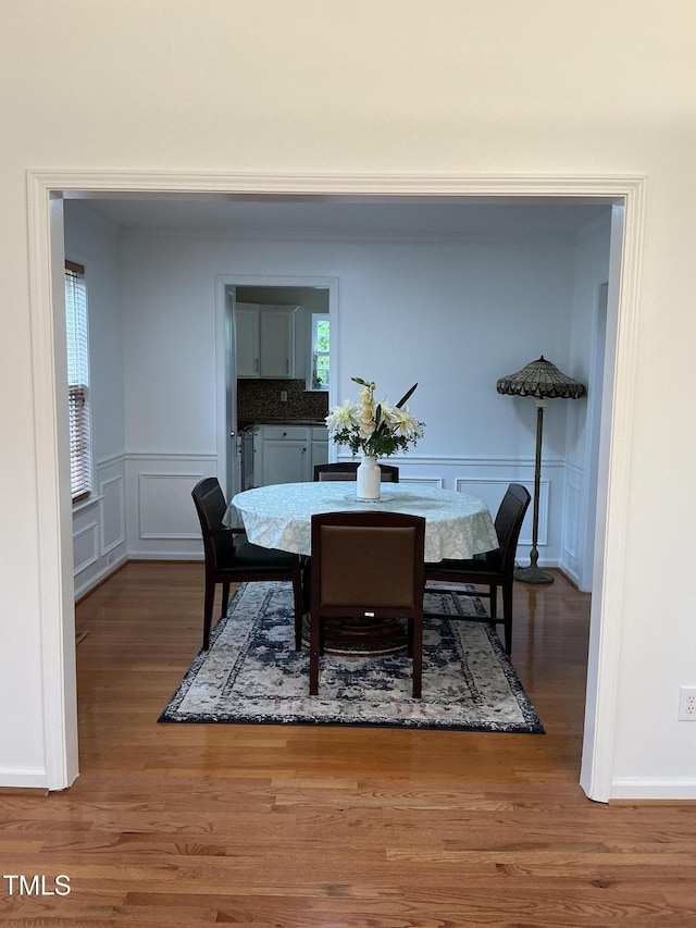 dining room featuring a decorative wall and wood finished floors