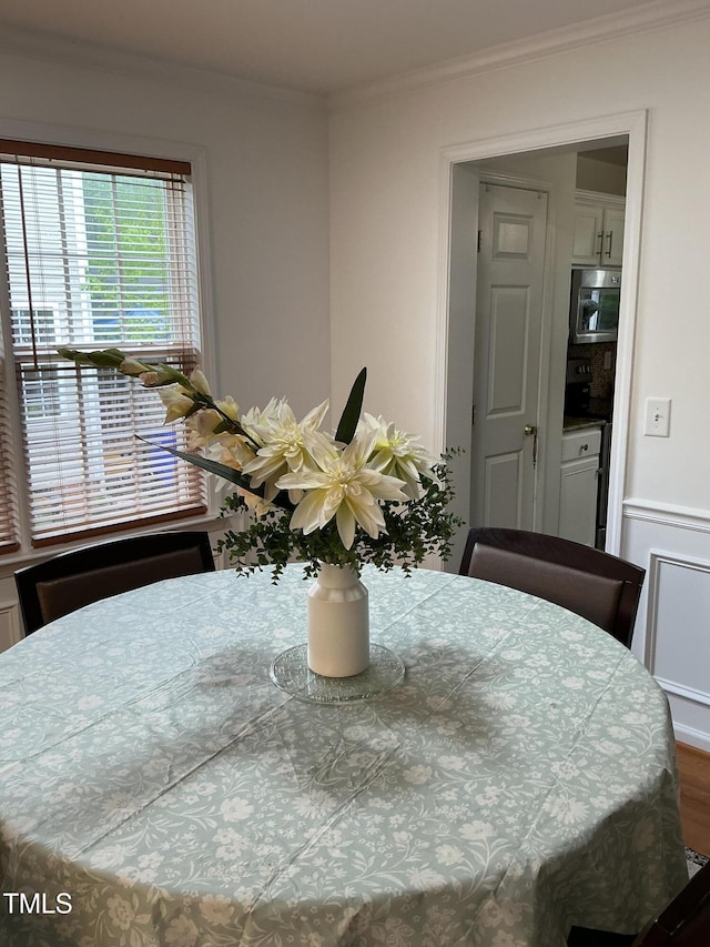 dining space with crown molding and wood finished floors