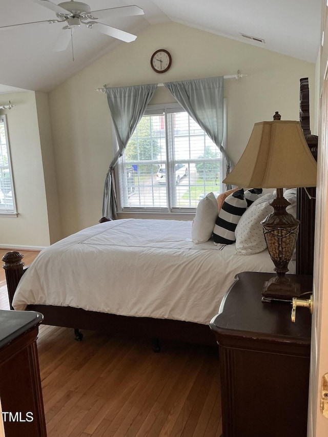 bedroom featuring visible vents, ceiling fan, vaulted ceiling, and wood finished floors