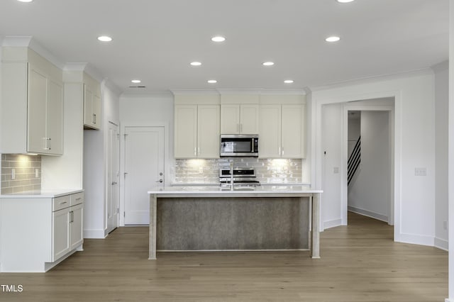 kitchen featuring a sink, light countertops, and stainless steel microwave