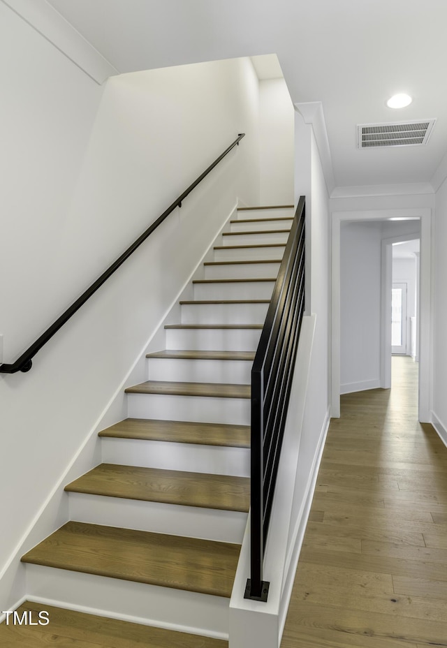 stairway featuring wood finished floors, baseboards, visible vents, and recessed lighting