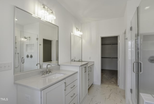 bathroom with a sink, a walk in closet, a shower stall, two vanities, and marble finish floor