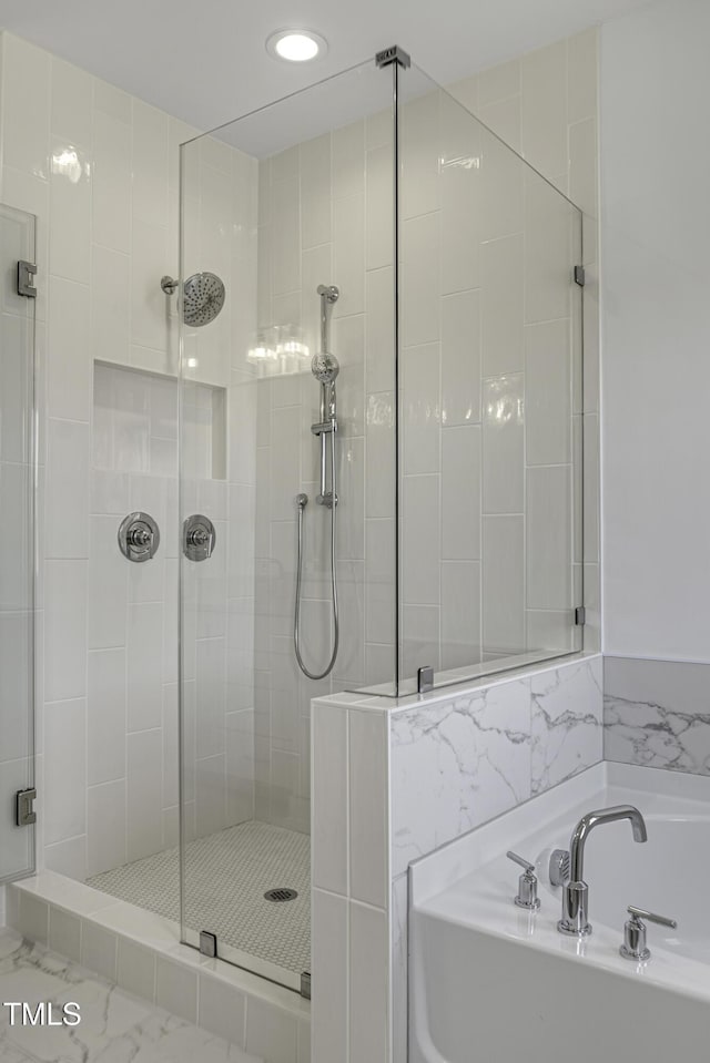 bathroom with recessed lighting, a garden tub, and a stall shower