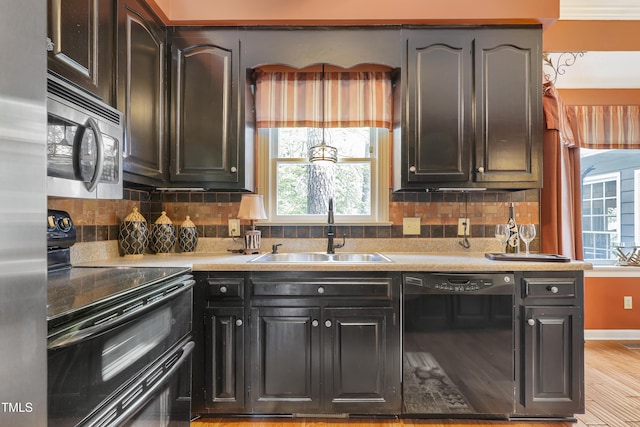 117 Vicksburg Dr, Cary, NC 27513 - kitchen with backsplash, light countertops, a sink, and black appliances