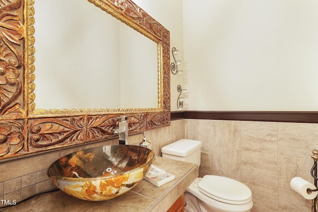 117 Vicksburg Dr, Cary, NC 27513 - bathroom with wainscoting, tile walls, a sink, and toilet