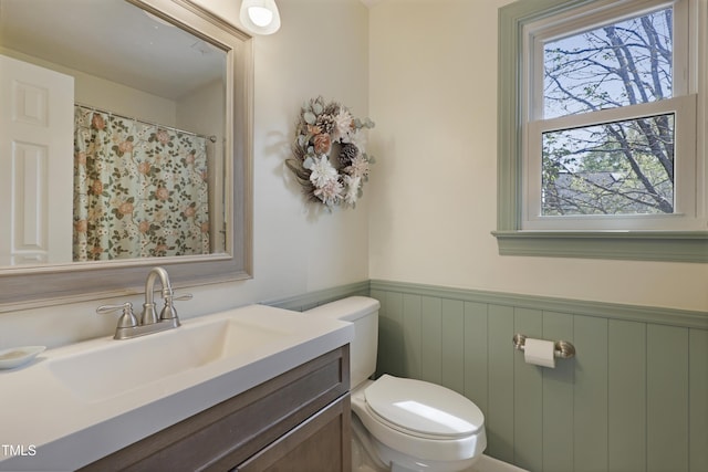 bathroom with toilet, wainscoting, and vanity