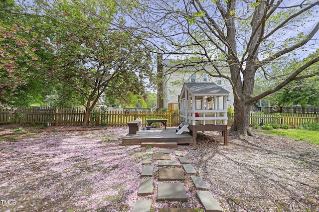 fenced backyard featuring a deck and an outdoor structure