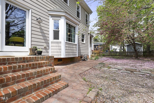 exterior space with fence, a patio, and crawl space
