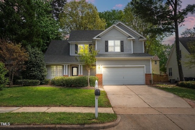 traditional home featuring driveway, an attached garage, a front yard, brick siding, and central AC