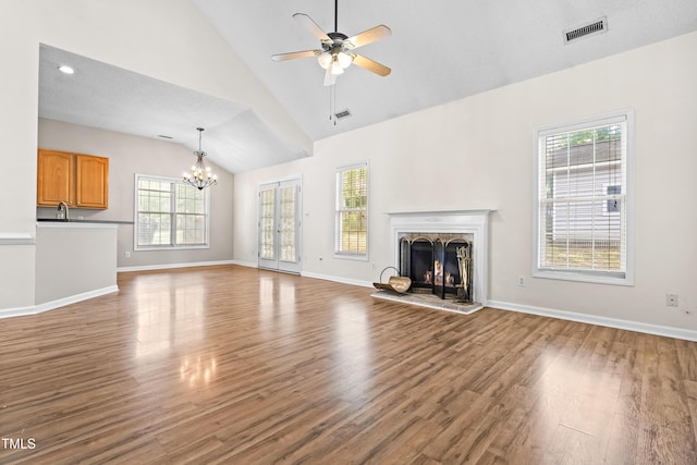 unfurnished living room with a healthy amount of sunlight, wood finished floors, and visible vents