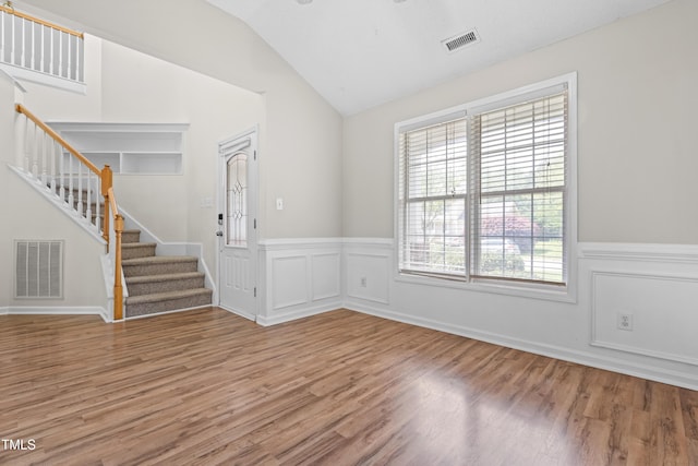 spare room featuring light wood-style floors, visible vents, and stairway