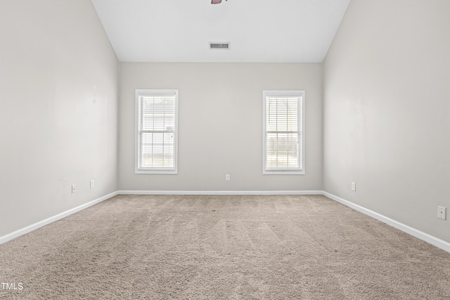 empty room with plenty of natural light, visible vents, baseboards, and carpet floors