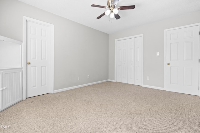 unfurnished bedroom with carpet floors, baseboards, a closet, and ceiling fan