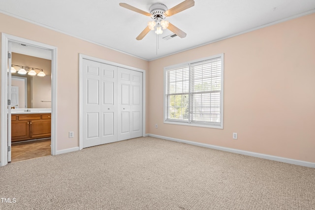 unfurnished bedroom featuring baseboards, a closet, light carpet, crown molding, and visible vents