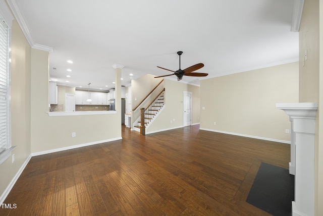 unfurnished living room with crown molding, baseboards, stairway, and a ceiling fan
