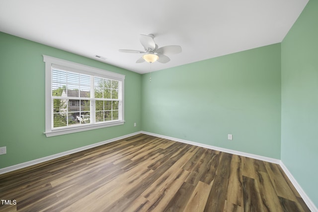 spare room with ceiling fan, baseboards, visible vents, and wood finished floors