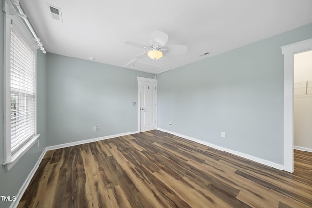spare room with wood finished floors, attic access, baseboards, and visible vents