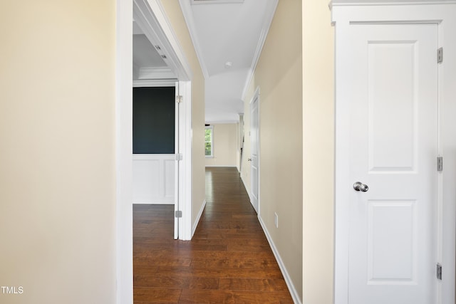 hallway with dark wood-type flooring and ornamental molding