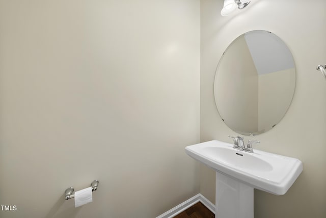 bathroom featuring wood finished floors, a sink, and baseboards