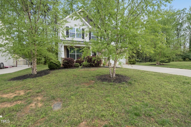 view of front of house with concrete driveway and a front lawn