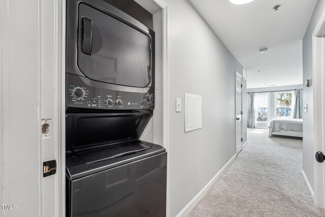 790 New River Inlet Rd Unit 113B, North Topsail Beach, NC 28460 - laundry room with baseboards, stacked washing maching and dryer, laundry area, and carpet