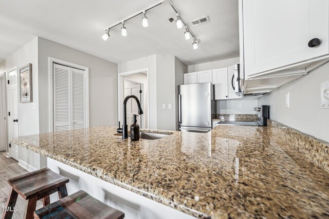 790 New River Inlet Rd Unit 113B, North Topsail Beach, NC 28460 - kitchen with range with electric cooktop, visible vents, a sink, freestanding refrigerator, and a peninsula