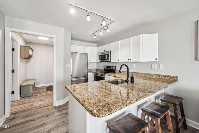 790 New River Inlet Rd Unit 113B, North Topsail Beach, NC 28460 - kitchen with a peninsula, appliances with stainless steel finishes, a sink, and baseboards