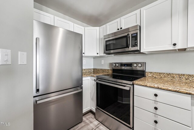 790 New River Inlet Rd Unit 113B, North Topsail Beach, NC 28460 - kitchen featuring stainless steel appliances, light wood-style flooring, white cabinetry, and light stone counters
