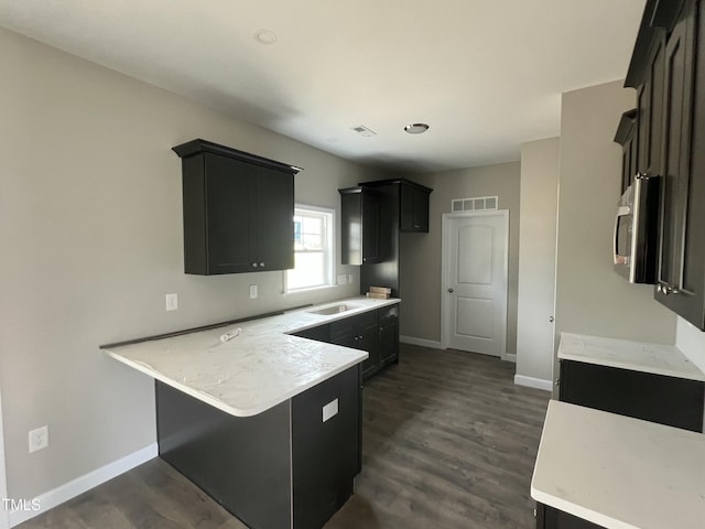 101 Waterstone Ct, Fremont, NC 27830 - kitchen featuring a peninsula, stainless steel microwave, dark cabinetry, light countertops, and dark wood-style flooring