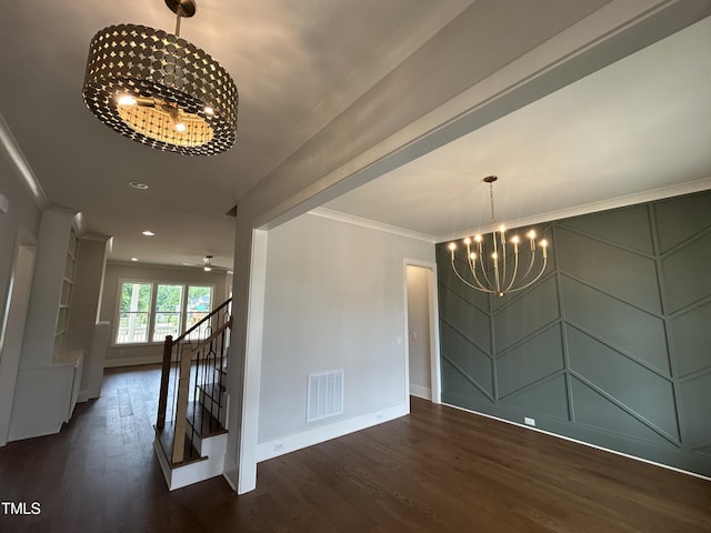 unfurnished dining area featuring a chandelier, wood finished floors, baseboards, crown molding, and a decorative wall