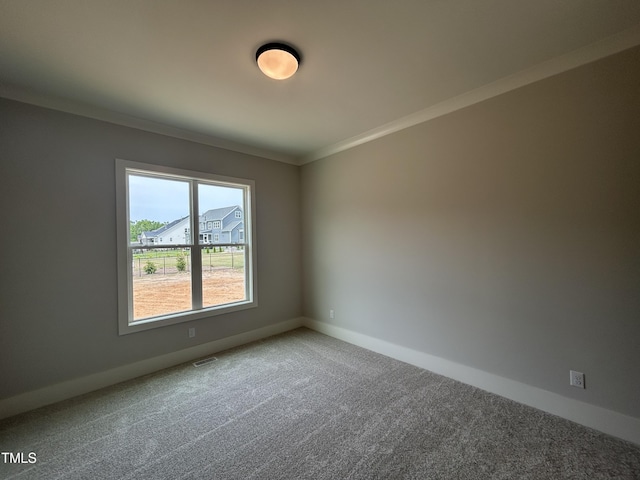 carpeted empty room with baseboards and crown molding