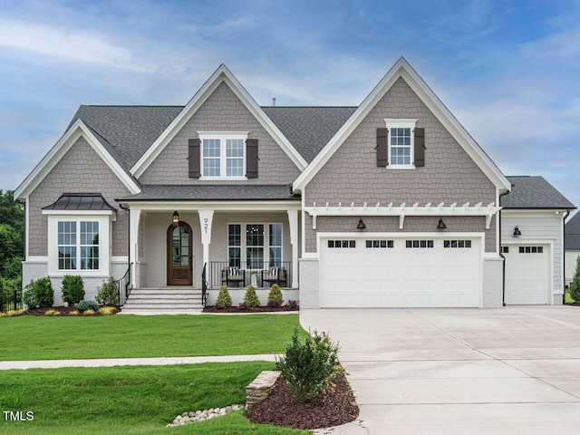 921 Lily Claire Ln, Fuquay Varina, NC 27526 - craftsman-style house with a porch, driveway, a front lawn, and an attached garage