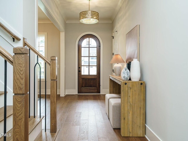 921 Lily Claire Ln, Fuquay Varina, NC 27526 - foyer with wood finished floors, arched walkways, a chandelier, crown molding, and stairs
