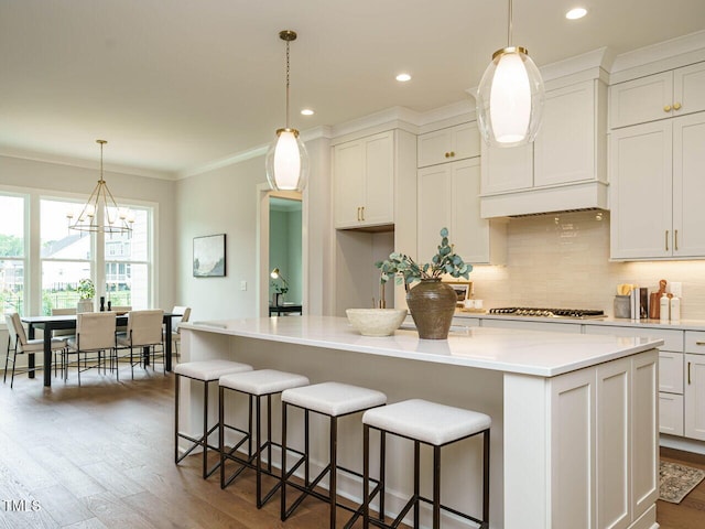 921 Lily Claire Ln, Fuquay Varina, NC 27526 - kitchen featuring decorative backsplash, dark wood finished floors, a chandelier, crown molding, and light countertops