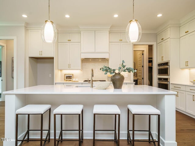 921 Lily Claire Ln, Fuquay Varina, NC 27526 - kitchen with decorative backsplash, white cabinetry, light countertops, an island with sink, and recessed lighting