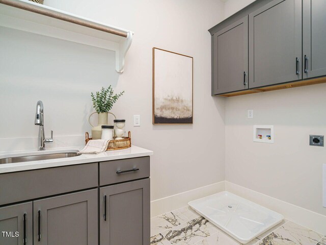 921 Lily Claire Ln, Fuquay Varina, NC 27526 - laundry area featuring electric dryer hookup, cabinet space, light marble finish floors, and washer hookup